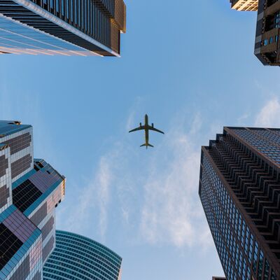 Flugzeug fliegt ber Wolkenkratzern.