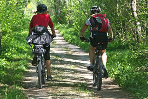 Zwei Fahrradfahrerinnen sind in der Natur unterwegs.