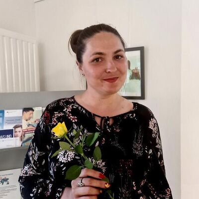 Eine Frau h&auml;lt eine gelbe Rose in der Hand.