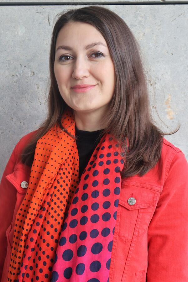 Ein Portrait von Elmira Kanava von der Koordinierungsstelle für Integration und Teilhabe. Sie trägt eine eine rote Jacke mit Schal.