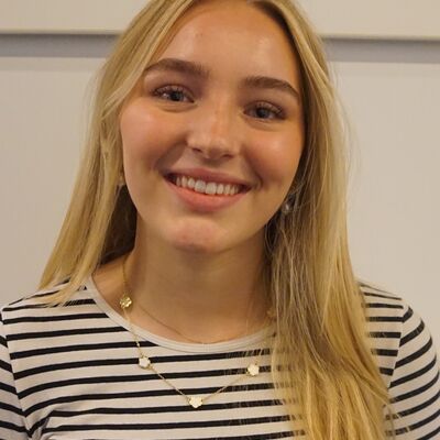 Eine blonde Frau mit einem schwarzweißen, langärmeligen T-Shirt.
