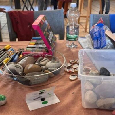 Auf einem Tisch liegen Stifte, Steine und weiteres Zubeh&ouml;r.