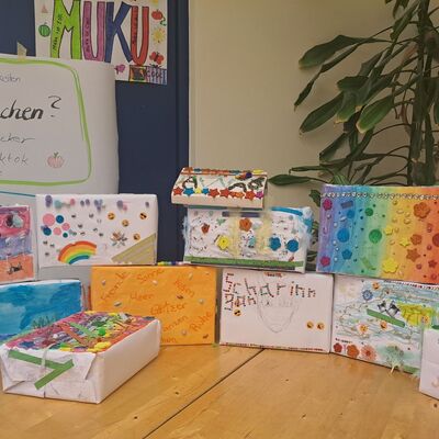 Auf einem Tisch liegen die Ergebnisse der Veranstaltung auf einem Tisch. Es sind bunt bemalte Schachteln.