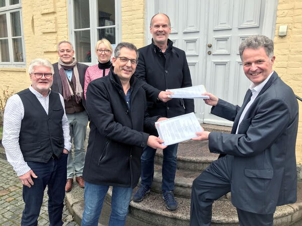 Von links nach rechts sind auf den Stufen zum Eingang des Hauses Segeberg wie folgt zu sehen: Jens Lichte, Manfred Stankat, Constanze Rode, Holger Lück, Hauke von Essen und Landrat Jan Peter Schröder.