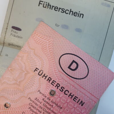 Zwei alte Führerscheine liegen übereinander. Der eine ist grau, der andere rosa.